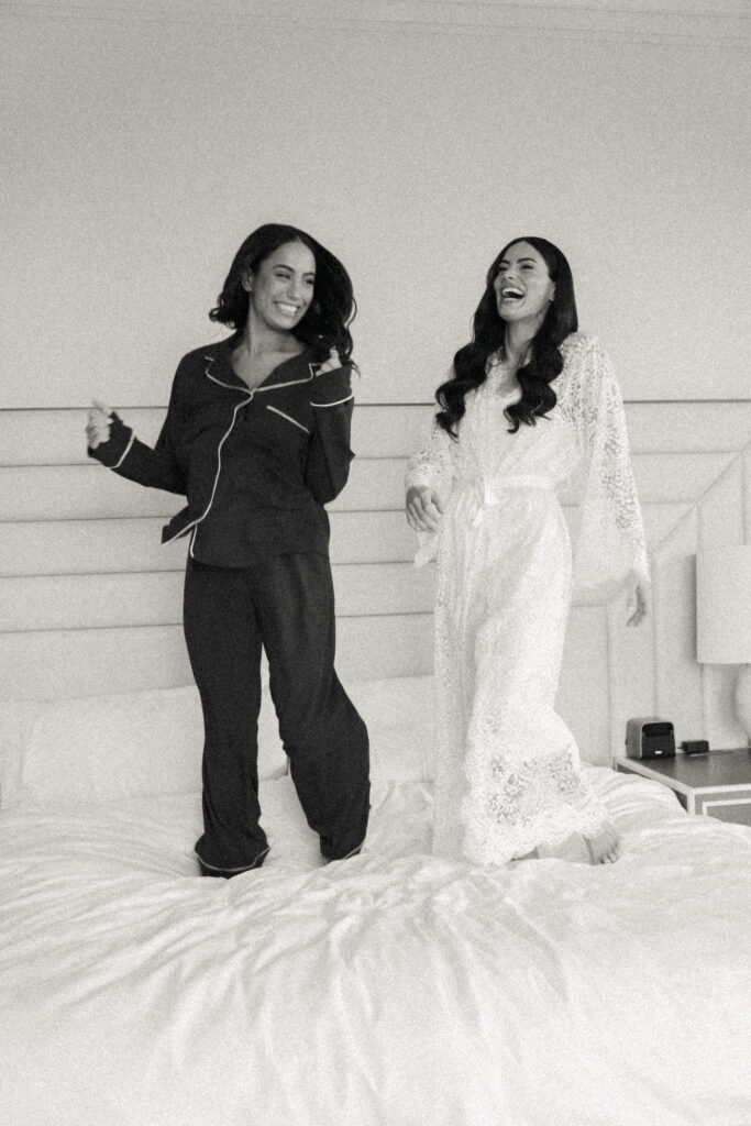 bridesmaids and bride jumping on bed
